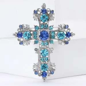 Elegant silver alloy cross brooch with blue crystals and intricate hollow carving