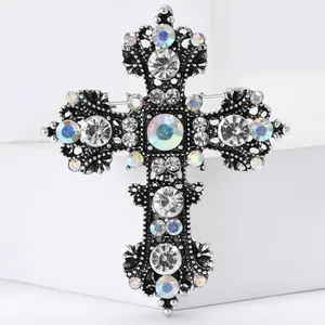 Macro detail of gothic hollow silver cross brooch with vintage crystals and engraving