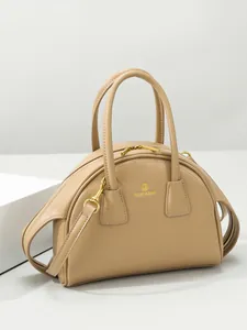 Minimalistische beige leren handtas in halvemaanvorm met logo en schouderband