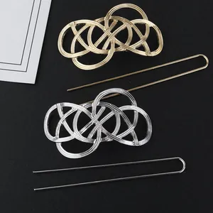 Detailed view of U-shaped gold and silver metal hairpins with intricate knot designs