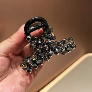 Macro detail of large hair claw clip with faceted dark grey crystal bead embellishments
