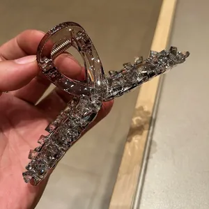 Close-up of large amber crystal hair claw clip with rhinestones and metal spring