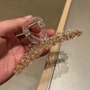 Close-up of champagne crystal claw clip with transparent acrylic and metal spring