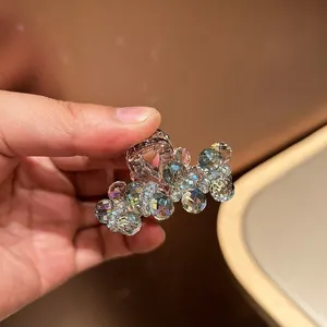 Detailed macro shot of rose gold metal hair claw clip with colorful iridescent crystals