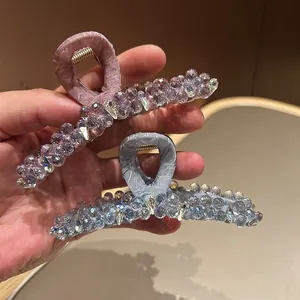 Detailed view of handmade beaded hair claws in purple and blue with crystal accents