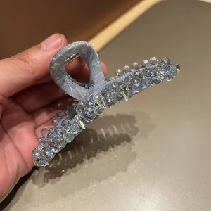 Detail of grey mesh hair claw clip with sparkling faceted crystal beads decoration