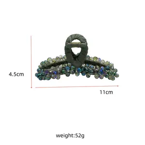 Macro shot of 11cm large vintage crystal beaded hair claw clip with dark green fabric