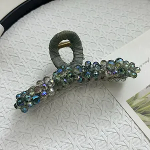 Macro shot of grey-green fabric hair claw clip with multi-color crystal beads
