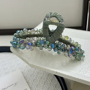 Detailed view of hand-beaded Morandi green large hair claw clip with colorful crystals