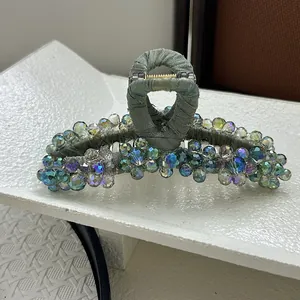 Macro detail of large hair claw clip with colorful crystal beads and textured fabric