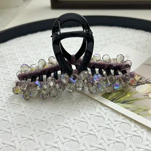 Macro detail of purple velvet hair claw clip with multifaceted crystal beadwork