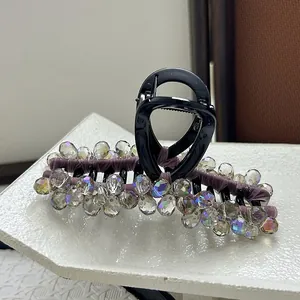 Macro shot of large purple crystal hair claw clip with faceted iridescent beads