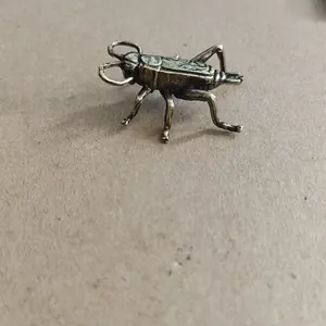 Detailed top view of a lifelike bronze cricket figurine with realistic insect textures