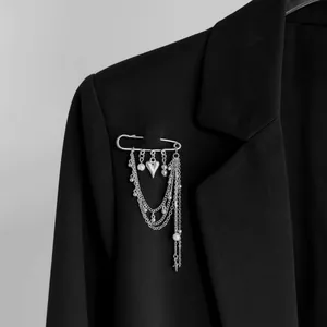Gros plan d'une broche à franges perlées argentées sur le revers d'un blazer noir