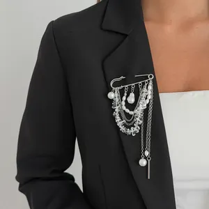 Détail d'une broche épingle argentée avec glands de perles multicouches sur un blazer