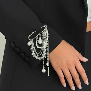 Détail d'une broche à franges avec perles irrégulières et cristaux sur une veste noire