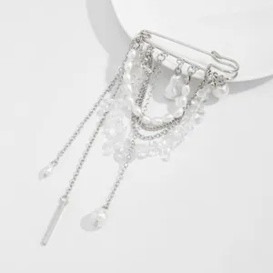 Détail de la broche avec chaînes à franges argentées et perles de cristal irrégulières