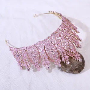 Macro detail of luxury pink gemstone crown with gold frame and teardrop crystals
