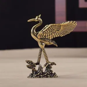 Close-up of vintage copper crane figurine showing intricate feather textures and base