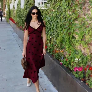 Détail de robe nuisette en satin bordeaux avec imprimé floral noir et décolleté en V
