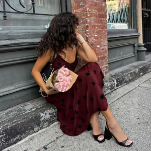 Détail de la robe à fleurs bordeaux avec bordure en dentelle noire et décolleté en V