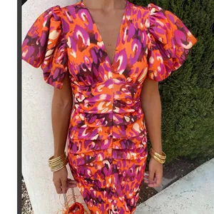 Close-up of the V-neckline and abstract leopard print on the slim fit dress