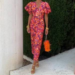 Detail of elegant V-neck dress featuring vibrant purple and orange abstract floral print