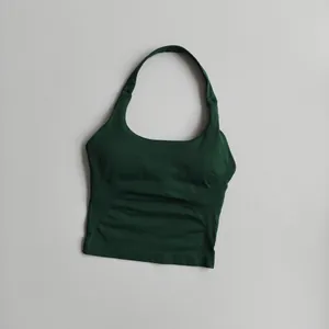 Detail showing forest green halter neck sports bra with ribbed texture and square neck