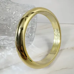 Macro detail of high-polish gold bangle showing reflective surface and thick structure