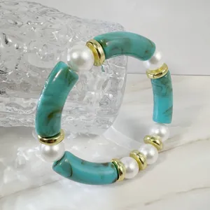 Detail view of bohemian elastic bracelet with blue marble resin tubes and pearls