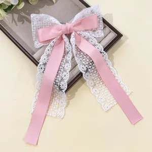 Détail de la pince à cheveux en satin rose et dentelle florale à longs rubans