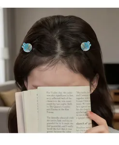 Blue acetate bunny hair clips worn on long dark hair showing miniature rabbit hairpins