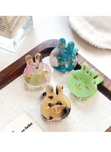 Detailed macro view of four mini acetate rabbit hair clips with marble patterns and gold engravings