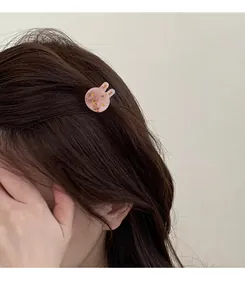 Close-up of a pink marble texture bunny hair claw clip worn on side swept hair