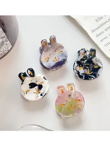 Detailed close-up of mini acetate rabbit hair claws with marble textures and gold accents