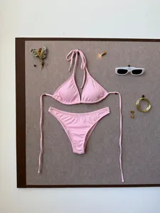 Flat lay of pink ribbed bikini set with sunglasses and summer holiday accessories