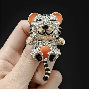 Détail d'une broche tigre scintillante en strass avec des touches d'émail orange