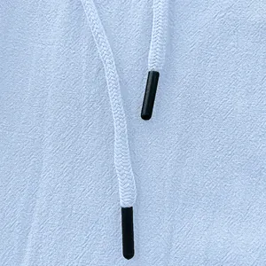 Macro shot of light blue linen trousers with white drawstring and black plastic aglets