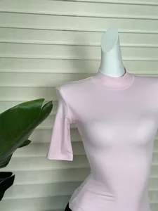 Close-up of pink mock neck slim fit T-shirt with structured shoulder pads and knit texture