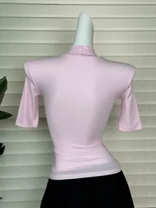 Slim fit light pink half-turtleneck top featuring shoulder pads and knit fabric