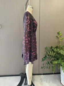 Detail of dark floral chiffon dress featuring ruffled edges and sheer long sleeves