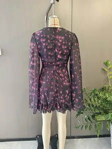 Rear view of long sleeve floral dress featuring ruffled hem and purple rose patterns