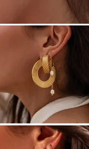 Detailed close-up of gold titanium ear wire with pearls and textured hoop earrings