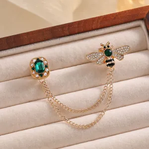 Exquisite gold bee brooch with emerald stones, pearls and chains on velvet box