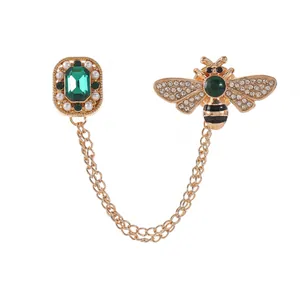Golden bee brooch set with emerald green stones, pearls and tassel chains