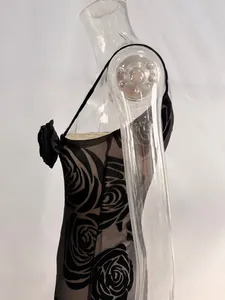 Close-up of mesh fabric with 3D floral accent and rose prints on a black dress