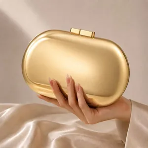 Gros plan de la pochette de soirée ovale dorée avec une finition métallique mate