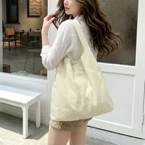Detail of floral embroidery and wide shoulder strap on a cream Sorakka tote bag