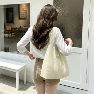 Detail of cream yellow mesh tote bag featuring exquisite floral embroidery and wide strap