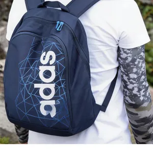 Outdoor view of a dark blue nylon backpack with white lettering and geometric lines